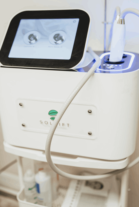 Professional medical-grade RF microneedling machine by Solift. The white console features a digital touchscreen display showing treatment settings and a handheld applicator resting in its dock